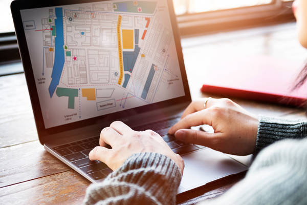 Man using map on laptop in communal space