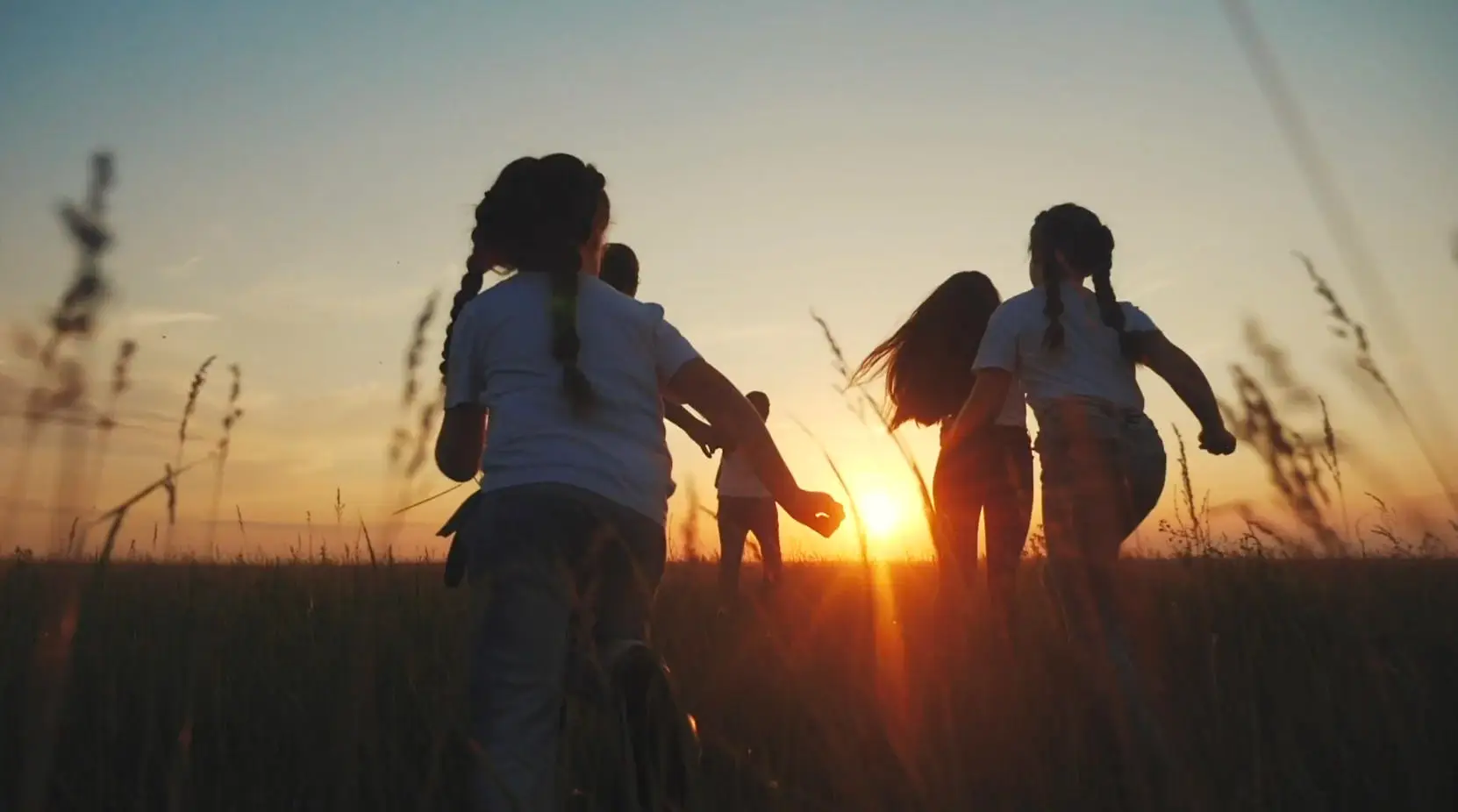 Family running into sunset