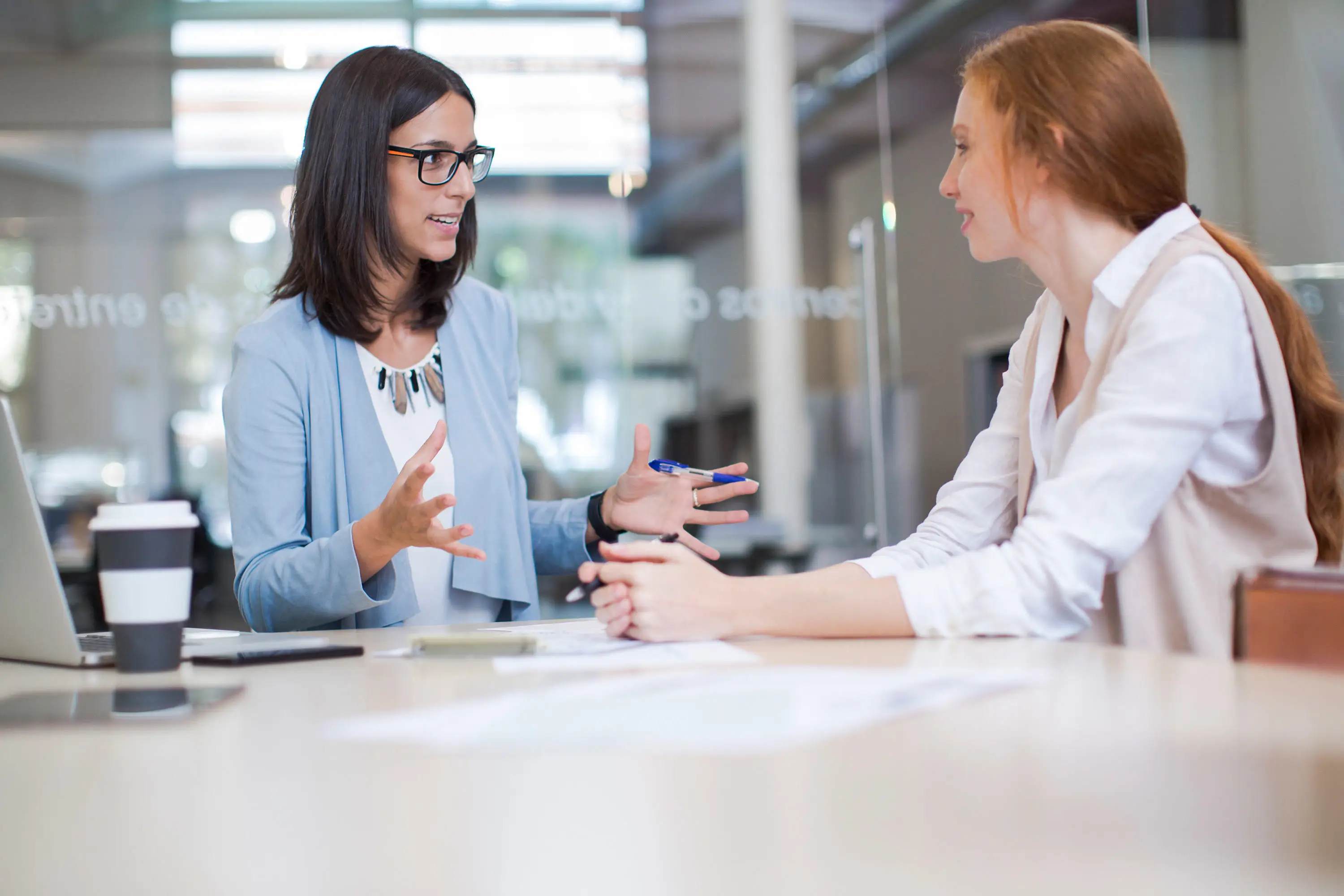 Two women talking in a meeting