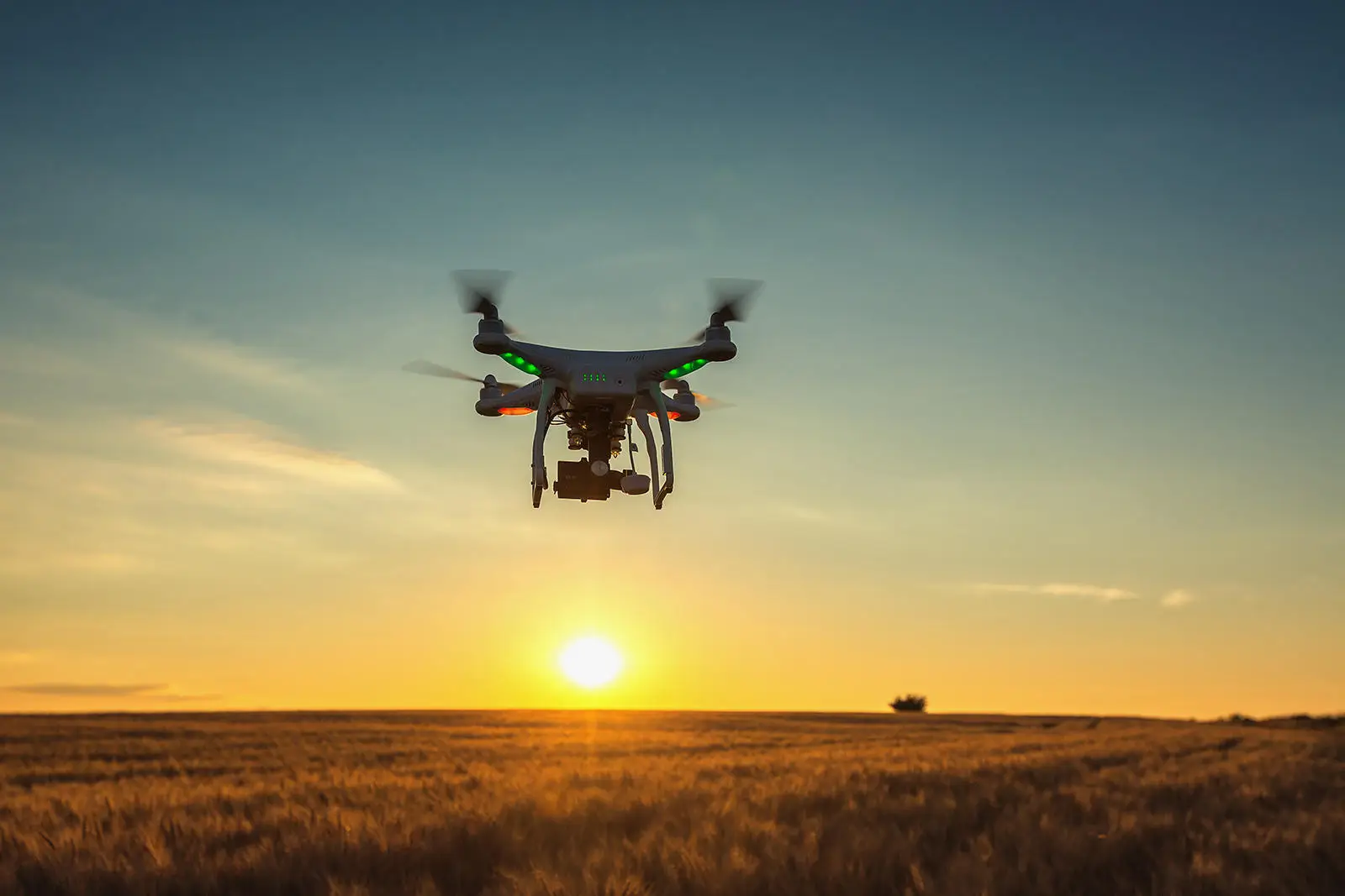 Drone flying in sky at sunset