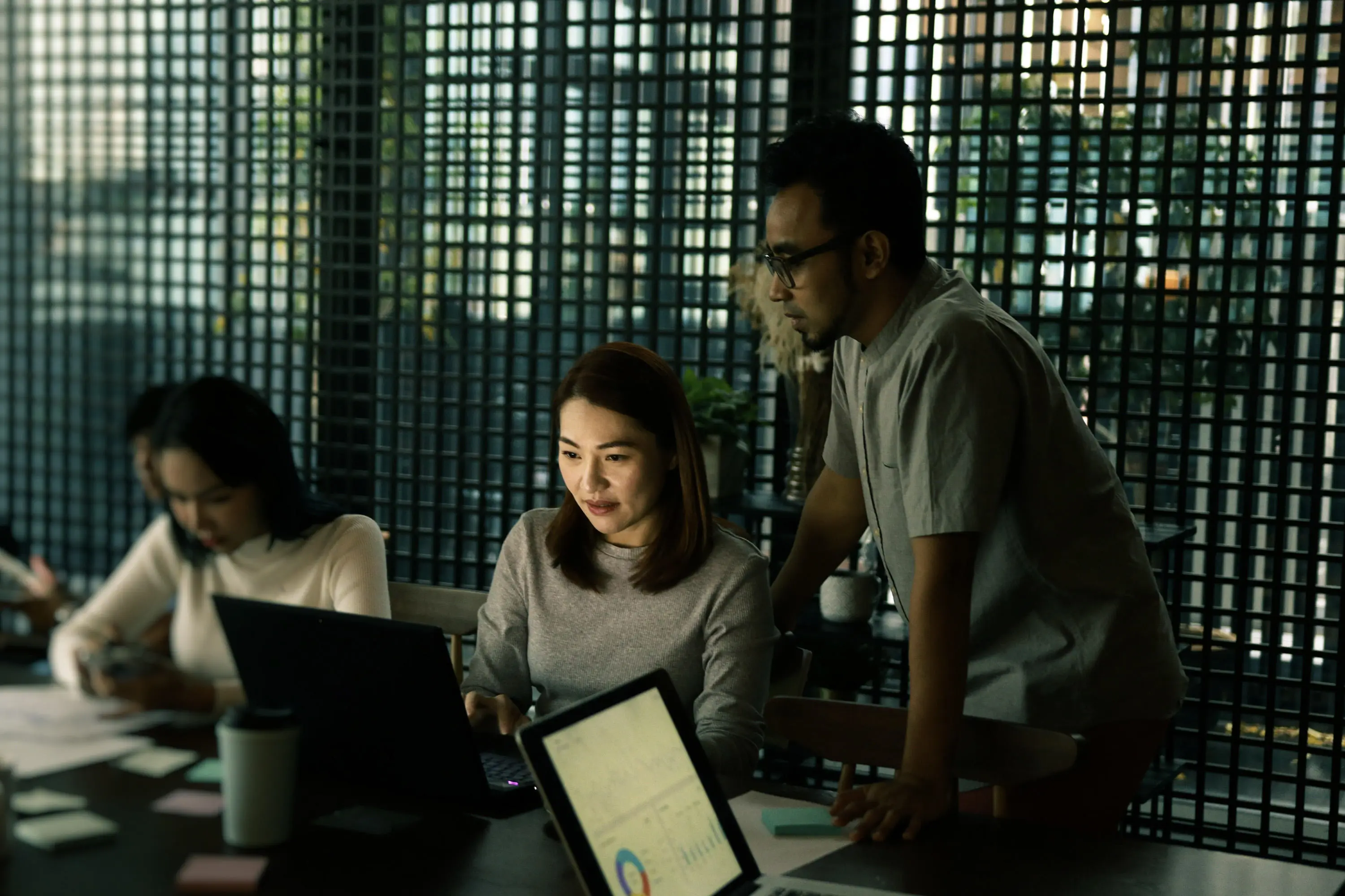Office environment two people looking at laptops