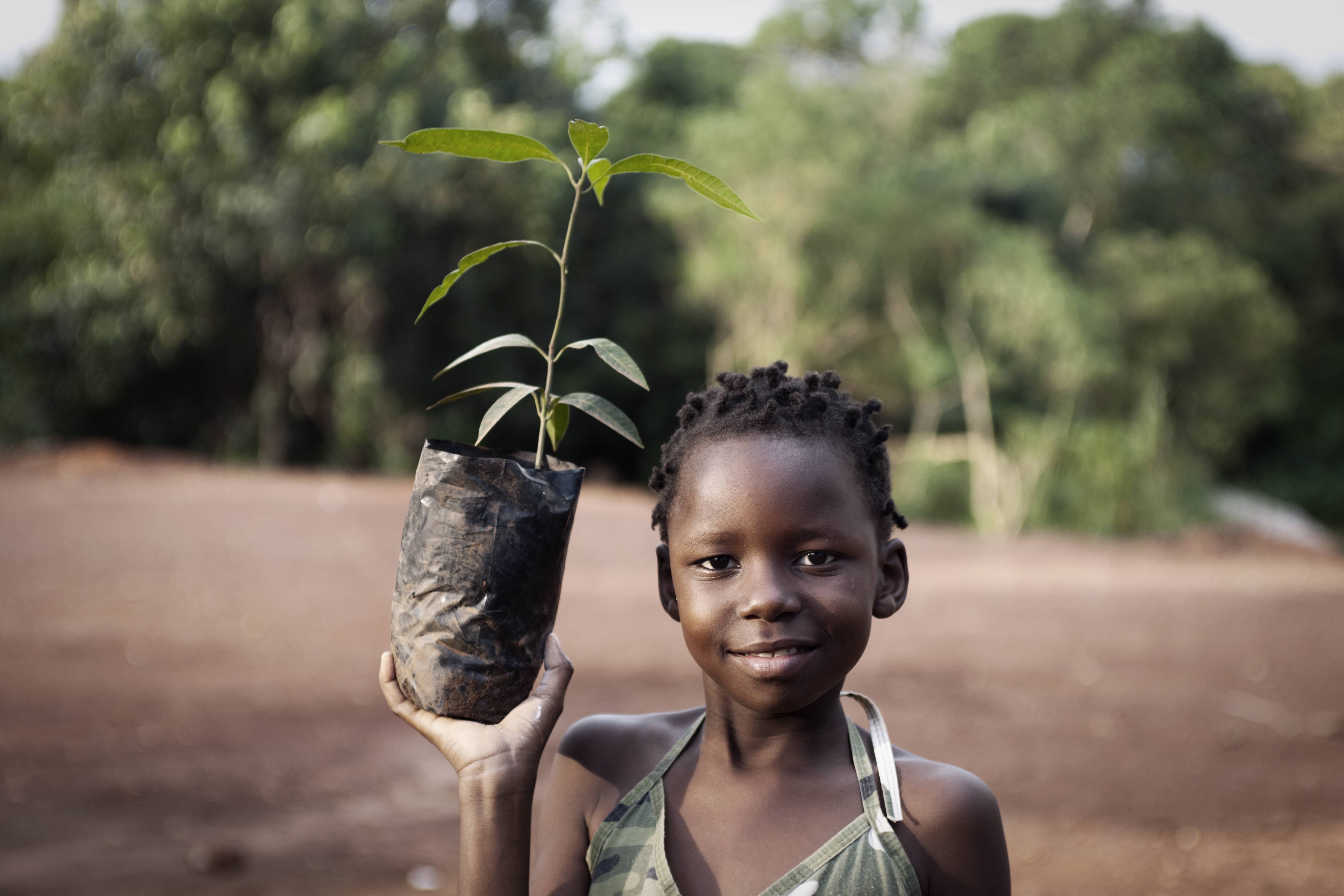 Girl in Africa holding a plant