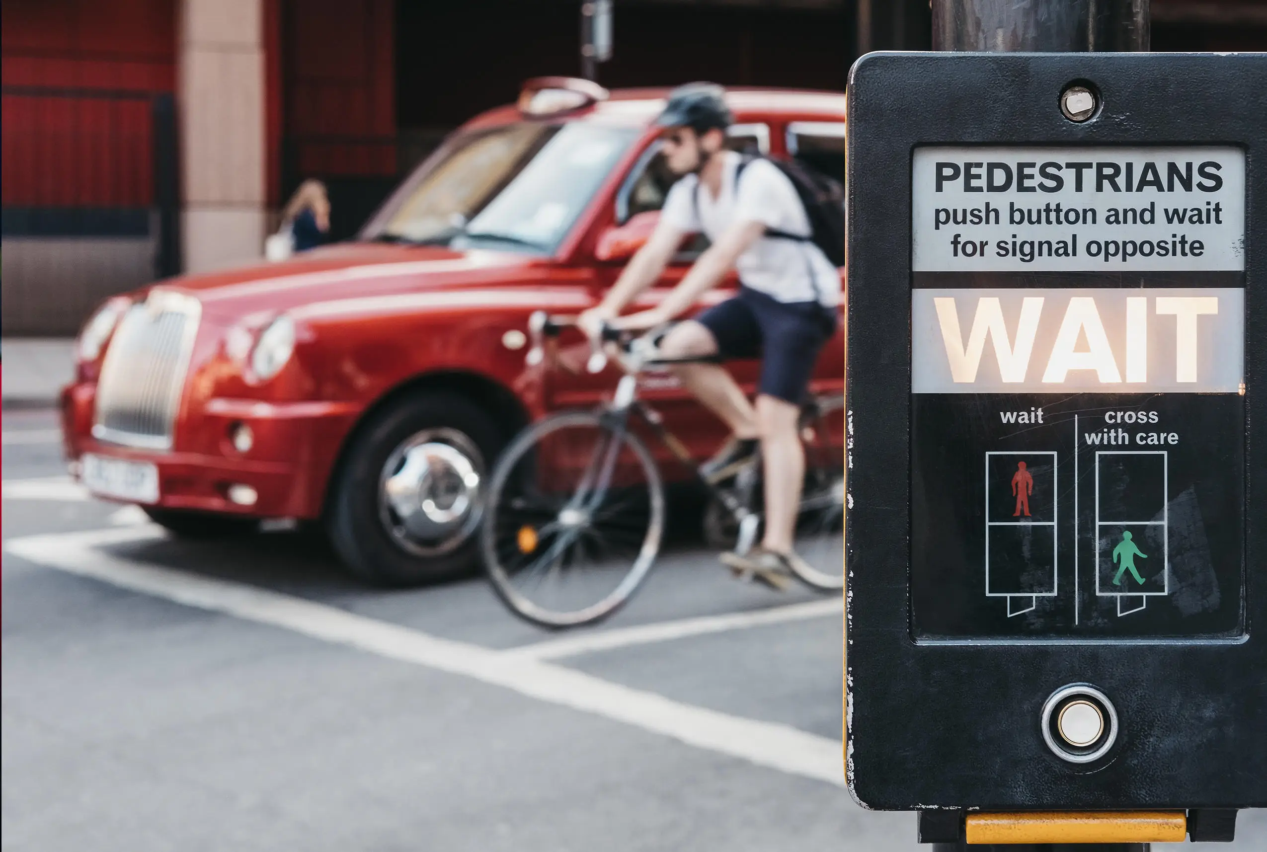 Taxi and cyclist waiting at street lights
