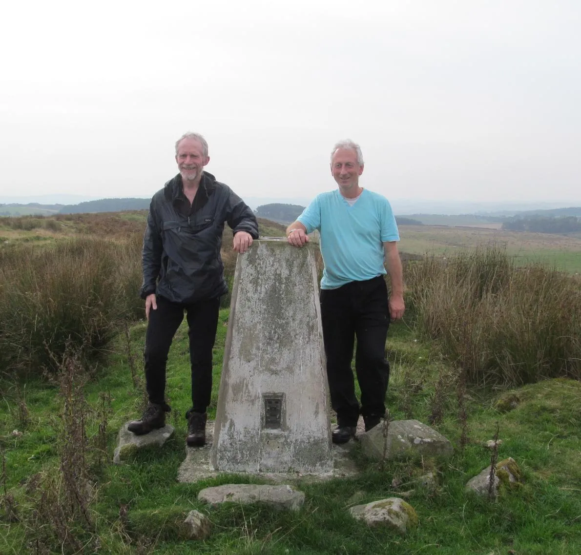 Rob Woodall and Graeme Paterson photographed next to a trig pillar.