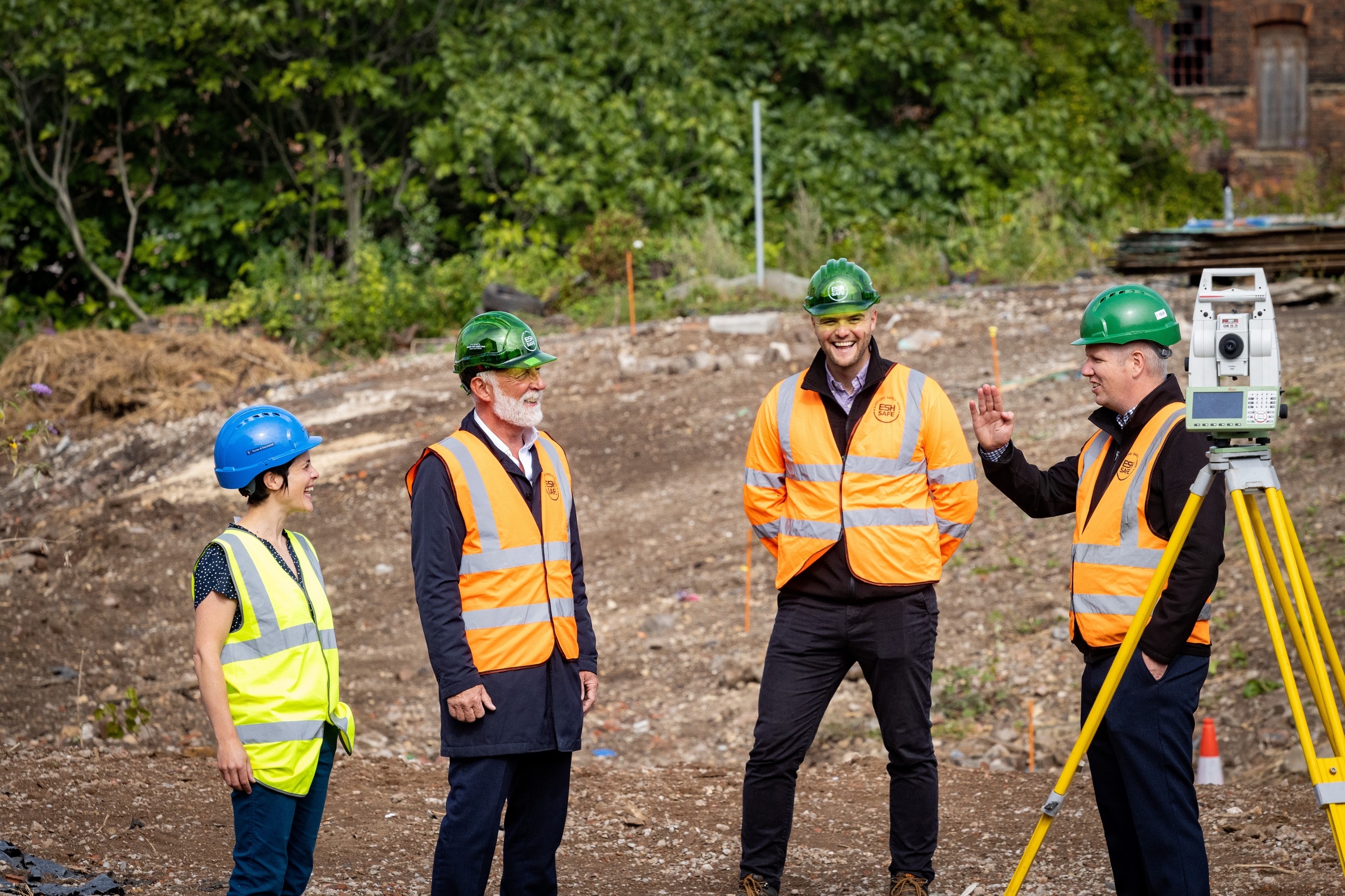 Four colleagues in high-vis standing in a construction site