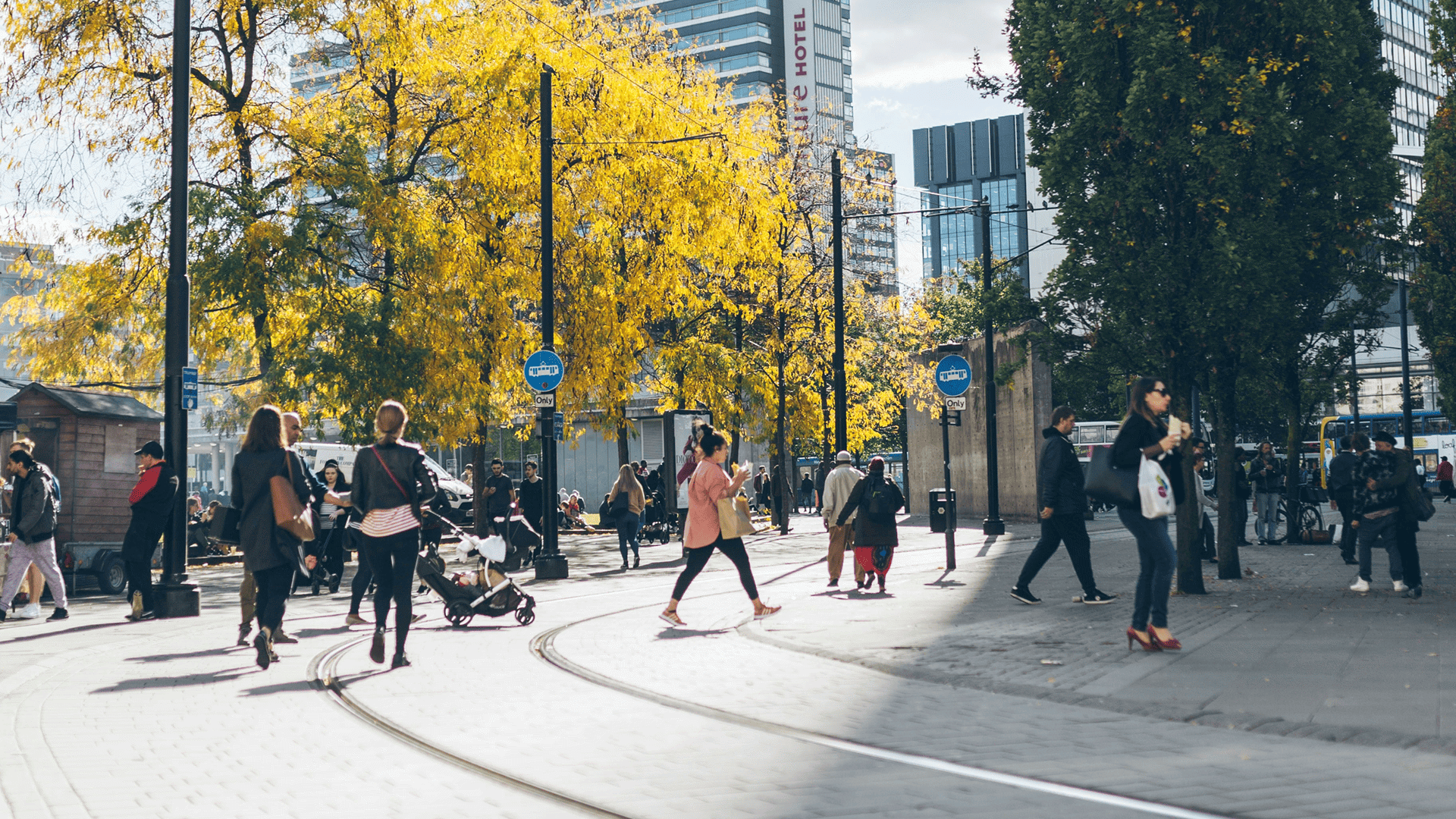 People walking safely across tram lines in a city