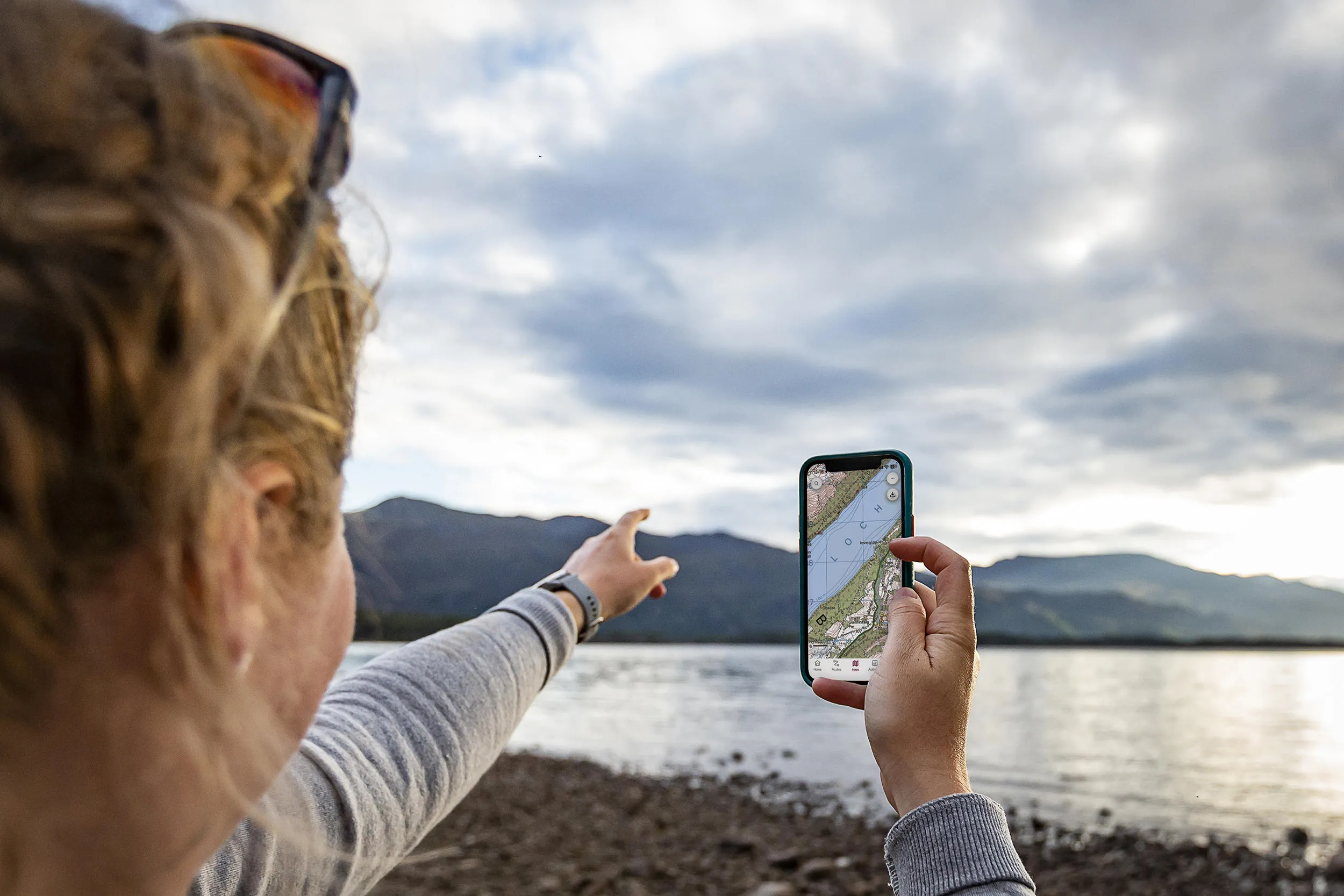 Woman using OS Maps app on her phone to navigate.